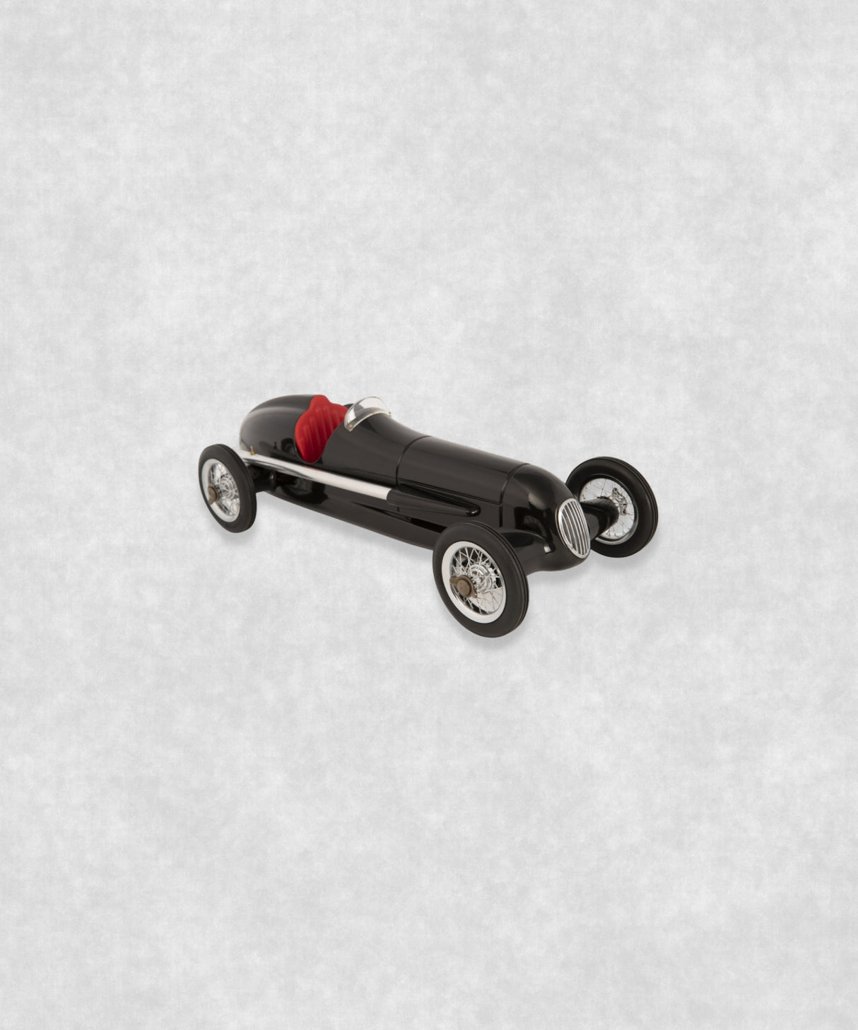 Vintage racing silberfeil car model inspired by classic Grand Prix racers and Silver Arrow legends, featuring a sleek black race car body with a striking red seat. A collectible car model for motorsport and classic car enthusiasts. Viewed from a front and side perspective.