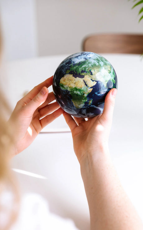 EARTH GLOBE ROTATING ON HANDS