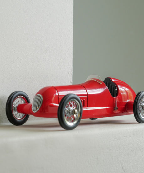 RVintage racing silberfeil car model inspired by classic Grand Prix racers and Silver Arrow legends, featuring a red race car body with a striking black seat. A collectible car model for motorsport and classic car enthusiasts. Viewed in situ