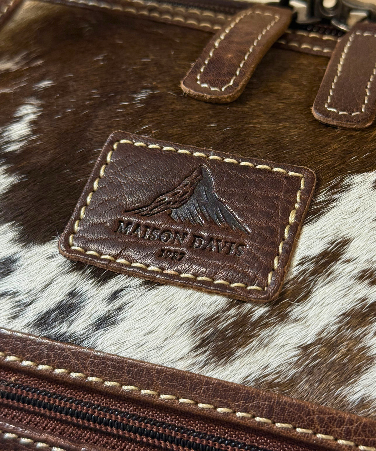 Close-up of cowhide travel bag leather texture and premium craftsmanship