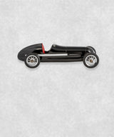 Vintage racing silberfeil car  model inspired by classic Grand Prix racers and Silver Arrow legends, featuring a sleek black race car body with a striking red seat. A collectible car model for motorsport and classic car enthusiasts. Viewed from  the left side.