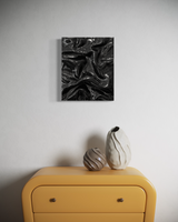 Black colored wall art by Sarah Kvejborg hanging on a neutral-colored wall.