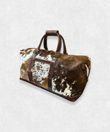 Side view of cowhide travel bag, showing durable leather and sturdy stitching