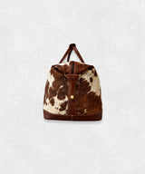Side view of premium cowhide leather travel bag showing durable stitching and stylish profile